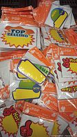 Various factory-sealed packs of retail price tag cards with promotional texts and graphics spread out, showing individual card designs labeled '8 Pop'.