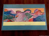 Full front view of framed print on wood floor, showing mat and silver metal frame