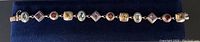 Full length view of bracelet on dark blue background showing overall design and gemstone sequence