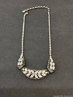 Full front view of the necklace laid flat on black background