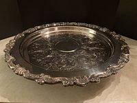 Top front angle view of the silver-plated Sheridan lazy Susan tray showing detailed carved edges and engraved floral pattern.