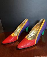 Pair of vintage Escada multicolor leather pumps showing side view with color block design in red, purple, yellow, and green.