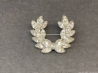 Front view of wreath-shaped rhinestone brooch