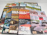 Photo showing the topline view of a stack of 20 Road & Track magazines from the 1970s and 1980s, showcasing various covers and car models.