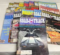 Set of 20 Road & Track magazines showing several different covers featuring classic car models, arranged fanned out on a flat surface.