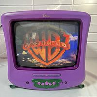 Front view of the purple Disney Fairies TV and DVD combo showing the screen displaying Warner Home Video logo