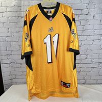 Front view of gold and black Hamilton Tigercats jersey with number 11 and CFL patch on neckline.