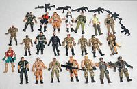 Top view of 24 military-themed action figures with 5 black rifles arranged on white surface.
