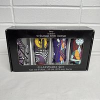 Front view of unopened box containing four glass tumblers with distinct Nightmare Before Christmas characters and scenes.
