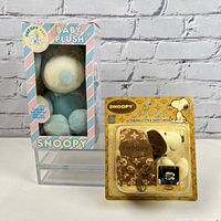 Snoopy Baby Plush Toy in pastel box and Snoopy stick shift cover in yellow card packaging.