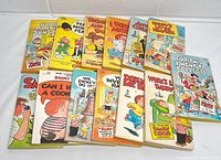 Top view of 12 vintage Family Circus comic paperback books arranged in two rows showing colorful covers with cartoon illustrations.