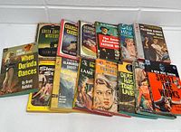 Full view of the 15 vintage pulp detective mystery paperback books laid out showing cover art and titles.