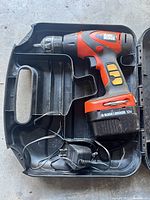 Black & Decker cordless drill inside the molded plastic carrying case with battery and charger.