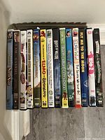 Side view of the 14 children's DVDs showing titles and condition