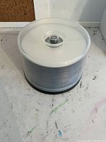 Large spindle of blank DVD+R discs sealed in clear plastic with black base, showing new condition.