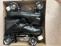 Top view of black Chicago Bullet men's speed roller skates in box showing wheels and boots.