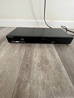 Front view of the Samsung Blu-ray disc DVD player showing the disc tray and front panel branding details