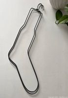 Photo of metal stocking hanger shaped like a stocking with hooking end for mantel display