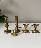Front view of all five brass items on flat surface with neutral background.