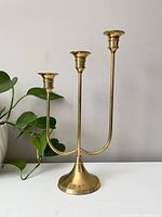 Full view of the vintage brass 3-arm tall candelabra with visible patina, showing the three candle holders and curved arms.