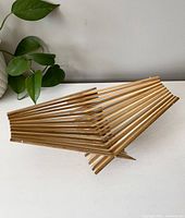 Photo showing the vintage wicker fruit tray in its folded form, highlighting the wooden slat construction and folding mechanism.