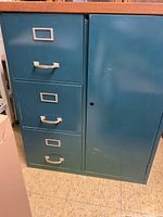 Front view showing three drawer file cabinet on left and vertical storage cabinet with door on right side.