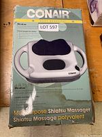 Box front showing the Conair Multipurpose Shiatsu Massager with handles and massage nodes in detail, with some wear and water stains on the box.