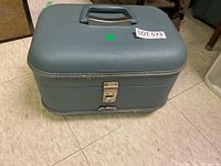 Photo showing exterior of the grey vinyl cosmetic case with handle and latch.