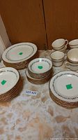 Full view of the vintage china set including stacks of plates, bowls, and cups and saucers arranged on a surface.