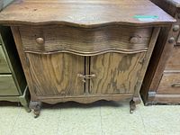 Front view of wooden wash stand showing curved drawer and two-door cabinet with string tie.