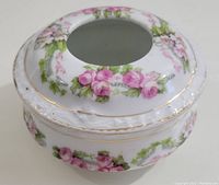 Angled top view showing floral pink rose pattern and open center of lid
