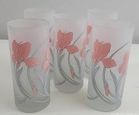 Five frosted cocktail glasses with pink floral design displayed together