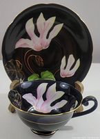 Front view showing tea cup inside saucer with floral design on both pieces