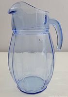 Side view of pale blue glass pitcher showing handle and body shape