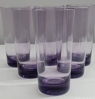 Front view of six purple crystal beverage glasses arranged in two rows.
