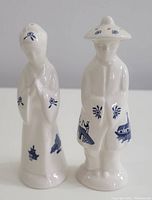 Front view of the Blue Willow Salt and Pepper Shakers shaped as a man and woman in traditional dress with blue scenic transfer pattern.