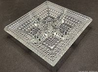 Top view of vintage clear glass ashtray showing hobnail texture and four cigarette rests.