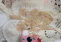Close-up of assorted vintage linens showcasing detailed lace work and colorful fabric