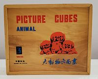 Wooden box top with printed text 'PICTURE CUBES ANIMAL', image of three puppies, and manufacturing info "Made in China".
