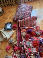 Camel saddle bag and cushions arranged on floor showing colors and tassels