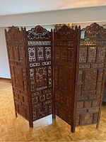 Full view of the four-panel folding screen showing overall carved design