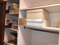 Shelf showing shoe boxes labeled Boots, and Jan Sanders Boots, with other boxed shoes visible.