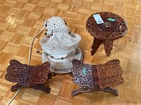 Overall view of all items in the lot, showing the carved wooden table, two wooden reading stands, and macrame light.