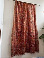 Full length front view of tapestry hanging on metal rail showing overall pattern and condition.