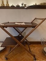 Full view of wood tea cart on caster wheels with two tiers