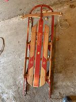 Top view of vintage Wards Hawthorne sled showing wooden slat seat, red painted details, and metal runners with steering bar.