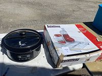 Photo showing Hamilton Beach slow cooker with digital controls and glass lid next to the box of the drawer organizer.
