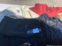 Four winter clothing pieces displayed including two Patagonia jackets, one North Face ski jacket and one pair of North Face ski pants.