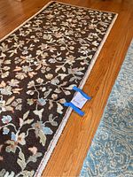 Close-up image of one brown handmade floral runner rug showing multicolor flower and foliage pattern