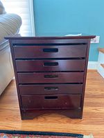 Front view of the wood end table showing five drawers with recessed handles